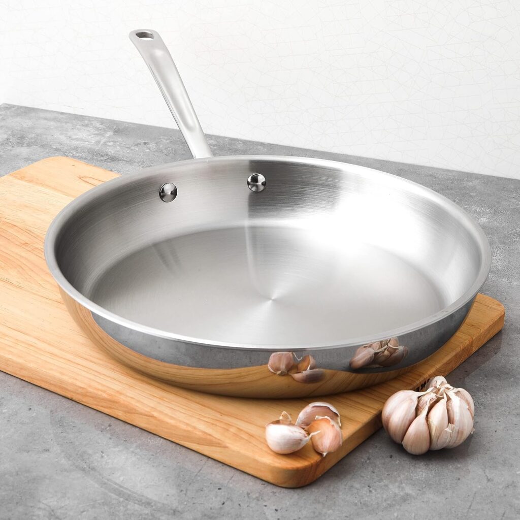 a stainless steel pan on a cutting board next to garlic pieces